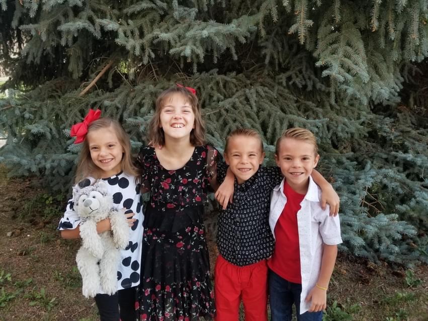 4 children in front of a tree 