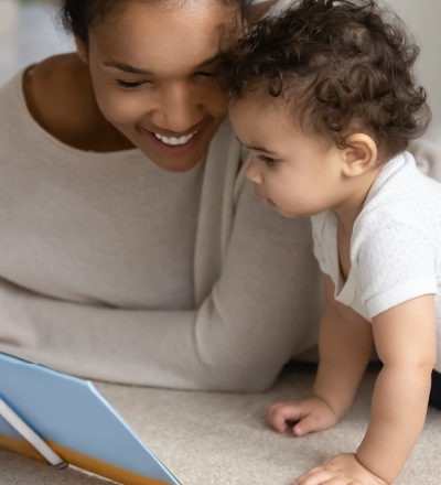 Mother and baby reading a book and smiling