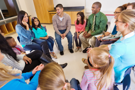 Parents and young children sitting in a circle.