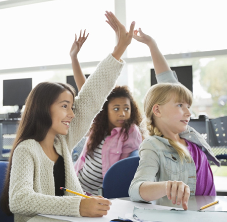 kids raising hand in a classroom