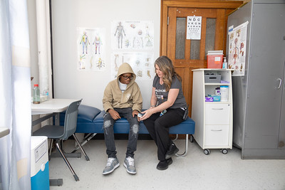 School Nurse sitting on cot with student