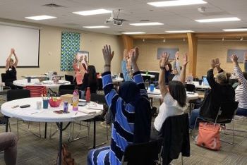 :People doing seated stretches at a meeting