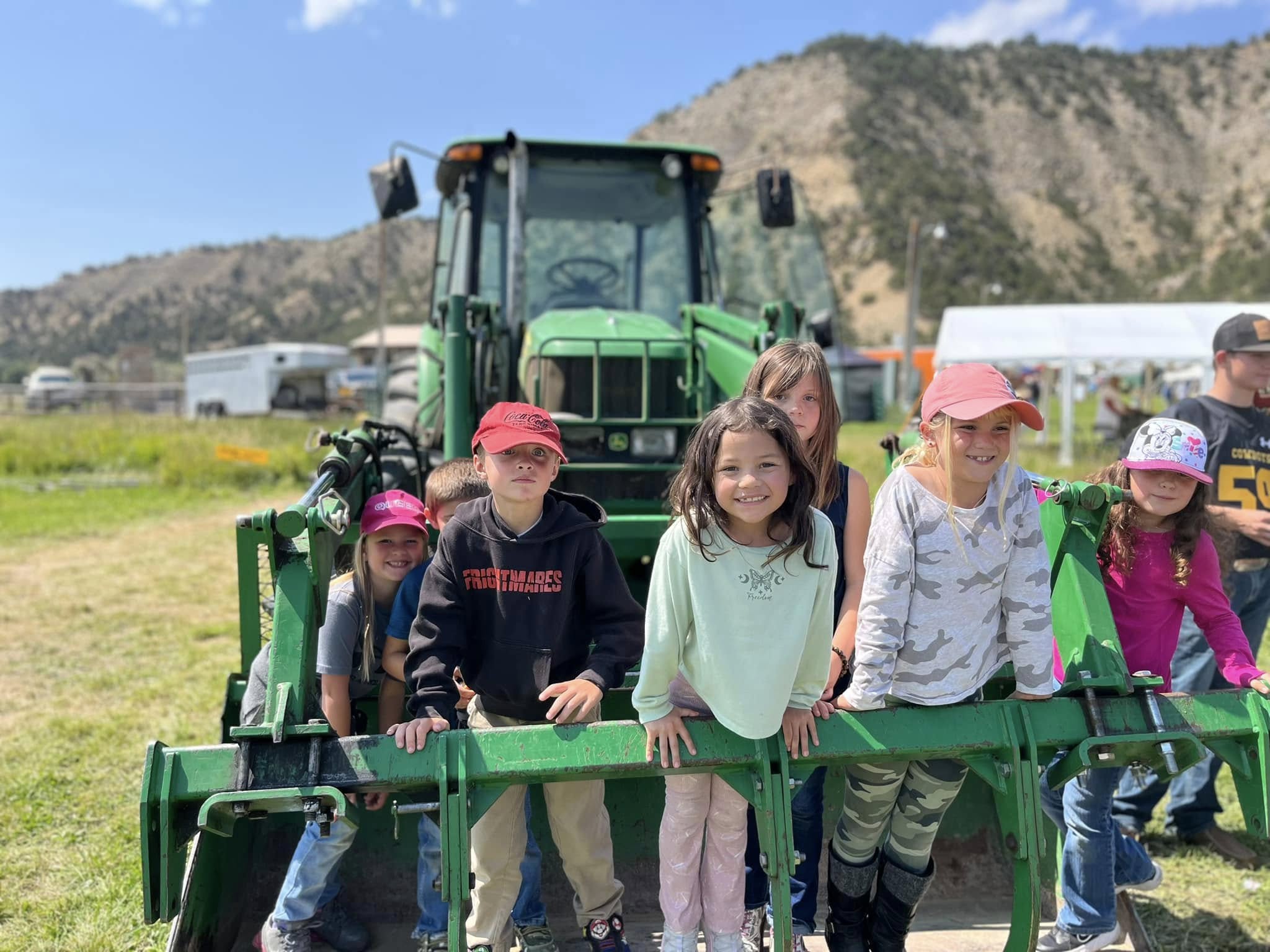 Students at Rangely School District enjoy playing on farm equipment during a sunny day.