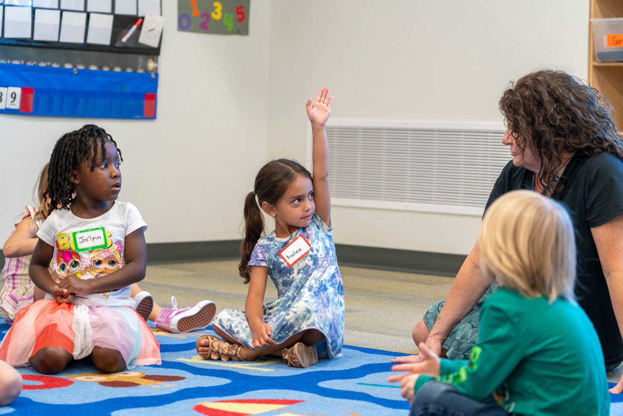 Child in Mapleton Public Schools raising her hand.