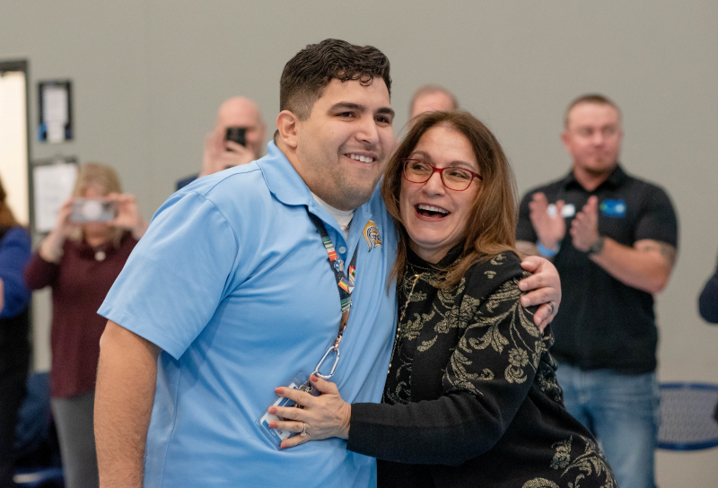 Caleb Flores, a teacher at Greeley West High School, celebrates with Commissioner Susana Córdova after winning the 2023 Milken Educator award on Dec. 15, 2023. 