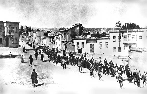 Armenian people are marched to a nearby prison in Mezireh by armed Ottoman soldiers. Kharpert, Ottoman Empire, April 1915