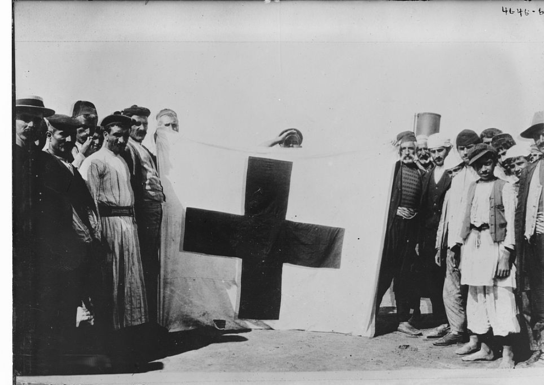 Armenians with the flag they used to signal for help after their resistance on Musa Dagh, Turkey during the Armenian Genocide. Photograph probably taken after their arrival at Port Said, Egypt, September 1915.