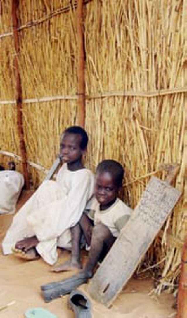 Two boys attend a makeshift school while in a refugee camp in Chad.