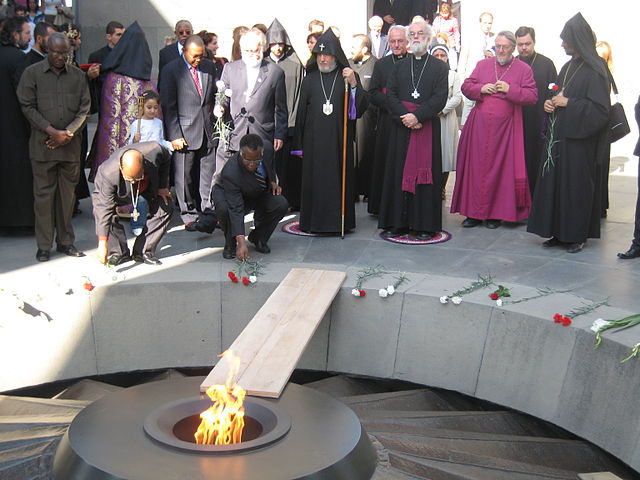 Archbishop of Canterbury Rowan Williams and Catholicos of all Armenians Garegin II at the Armenian Genocide monument in Yerevan for a torch lighting ceremony for the genocide victims in Darfur. The two men are standing on purple cloth, with Garegin on the left and Williams on the right.