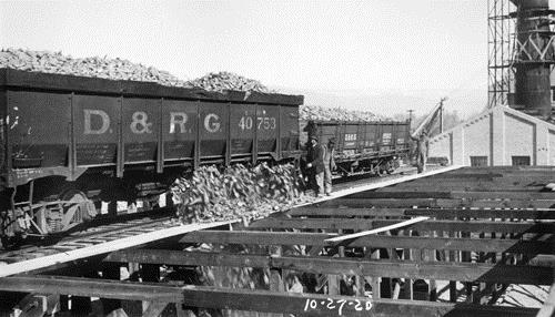 Men watch beets pour from a D.& R.G. railroad freight car 
