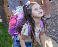Young girl with a backpack smiling and ready to go