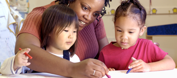 Teacher helping two young girls