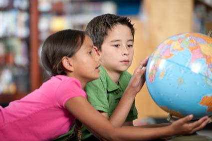 elementary students looking at a globe